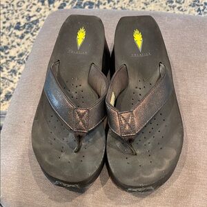 Volatile Bronze Footwear with Bold Yellow Logo